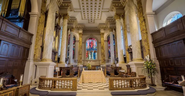Elegant interior of historic English cathedral featuring grand columns and stained glass.