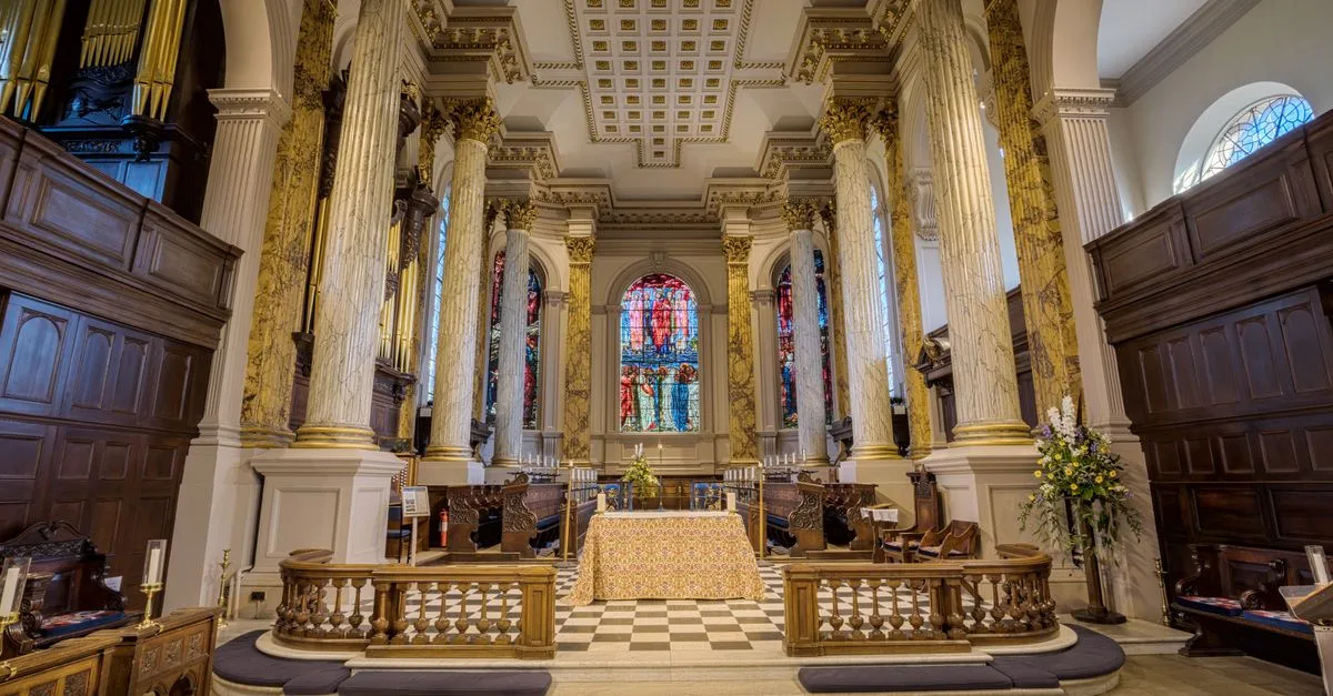 Elegant interior of historic English cathedral featuring grand columns and stained glass.