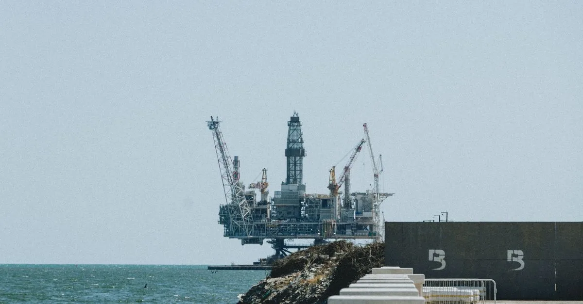 Distant view of an offshore oil rig with cranes on a sunny day.
