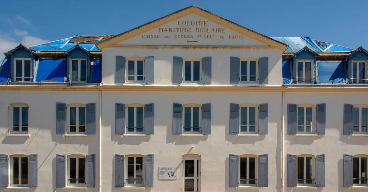 Photo of a historic maritime school facade under restoration in Quiberon, France.