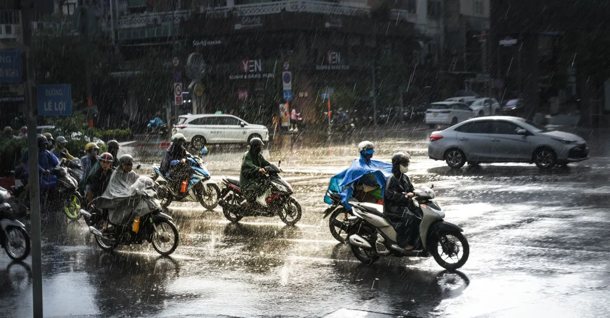 Motorcyclists navigate a rainy intersection in Ho Chi Minh City, showcasing urban resilience and mobility.