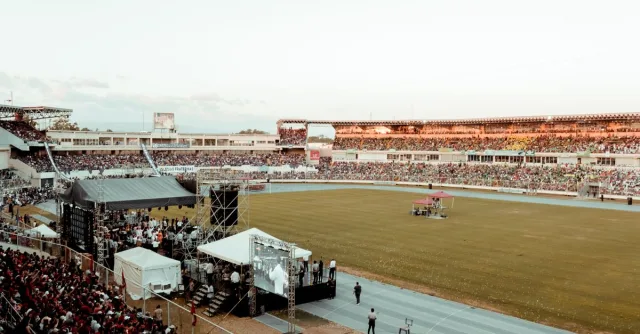 A lively crowd gathers at a football stadium during an outdoor event, showcasing spectator excitement.