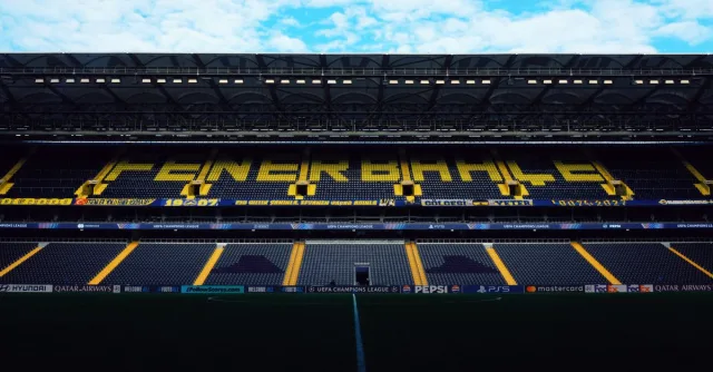 Interior view of Fenerbahçe Stadium with empty seats and bright signage.