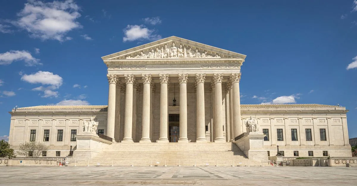 The majestic facade of the United States Supreme Court under a clear blue sky.