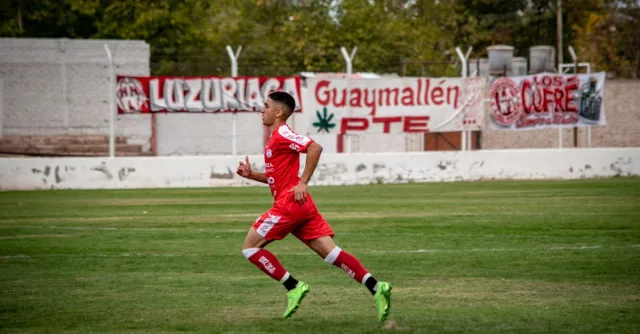 Dynamic shot of a young soccer player running on a football field during a match.