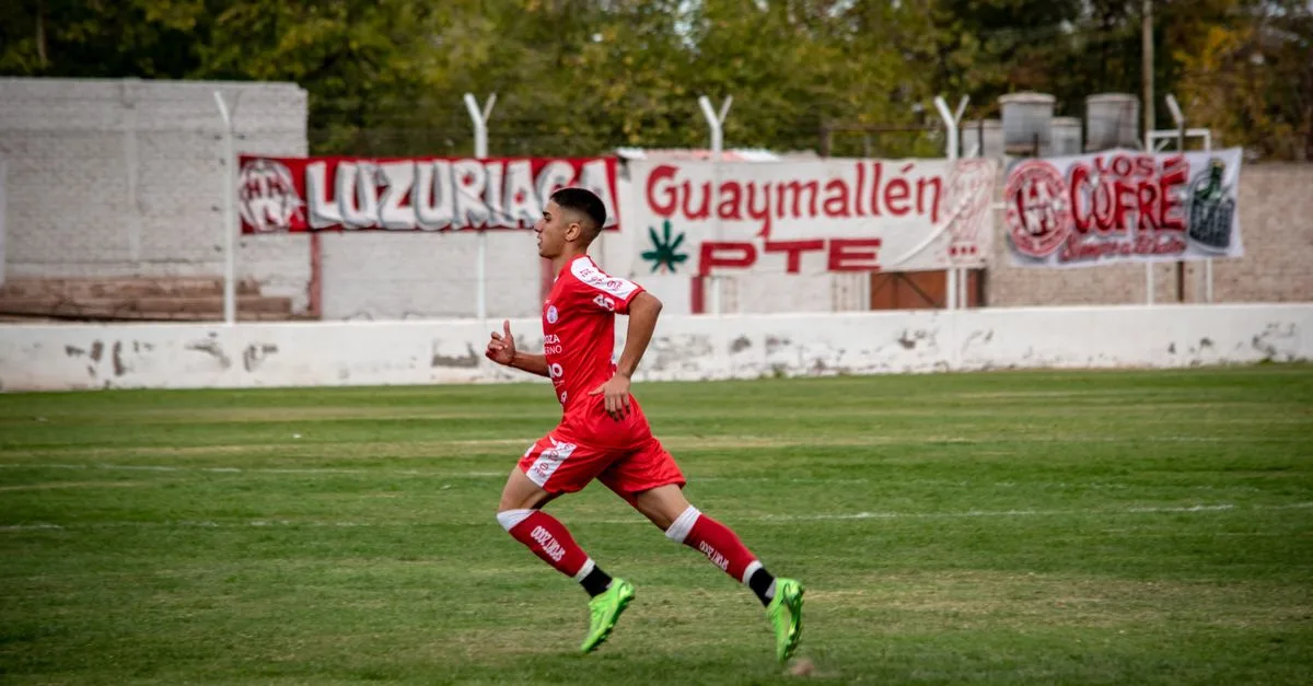 Dynamic shot of a young soccer player running on a football field during a match.