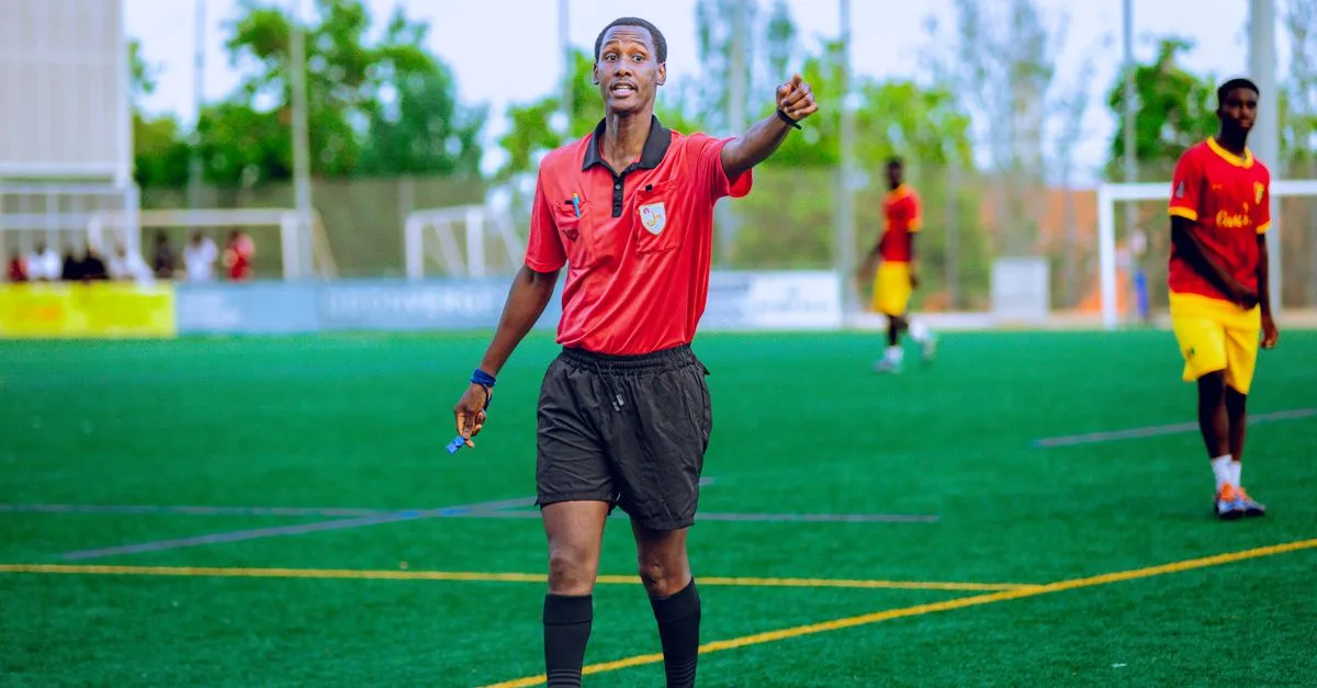 Referee in action during a football match, outdoors on a green field.