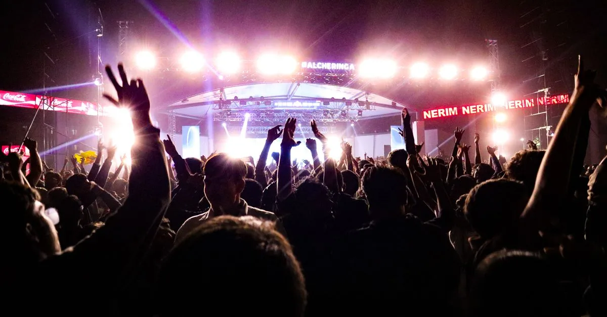 Energetic crowd enjoying a live concert under bright stage lights in Guwahati, India.