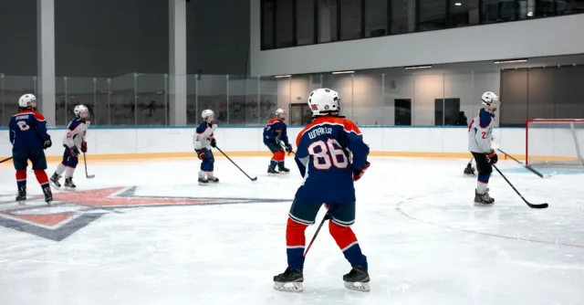 Action shot of a youth ice hockey game in an indoor rink, highlighting team sportsmanship.