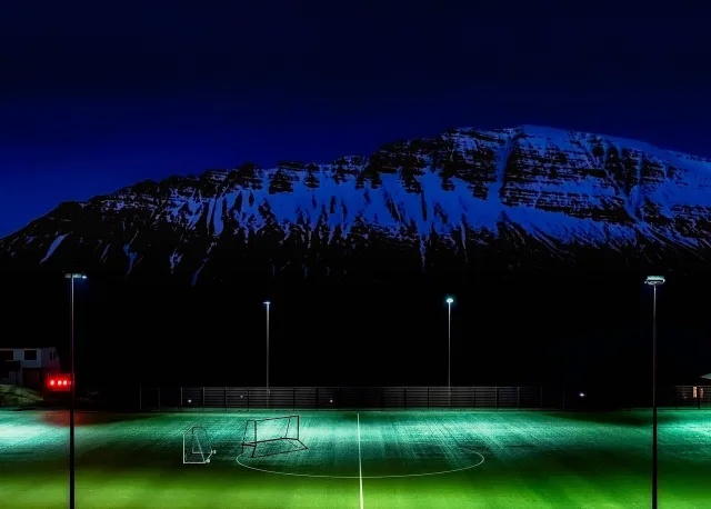 Opplyst fotballstadion under en kveldskamp.