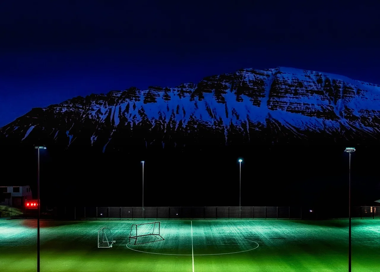 Opplyst fotballstadion under en kveldskamp.