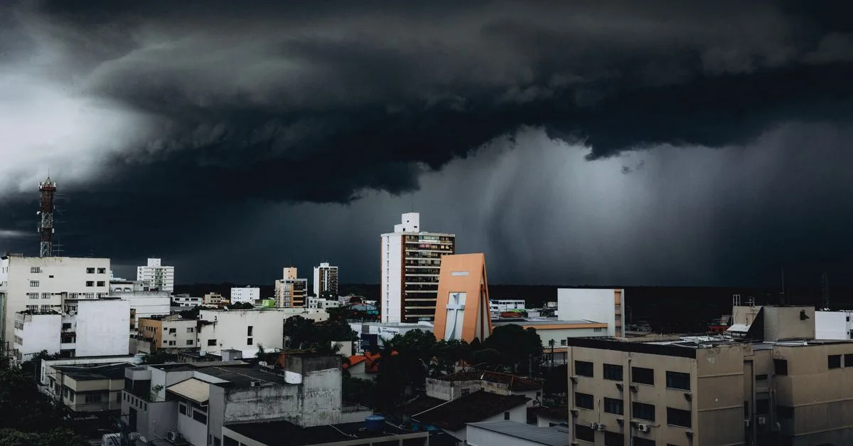 Dramatic storm clouds hover over city skyscrapers, creating a moody urban landscape contrast.