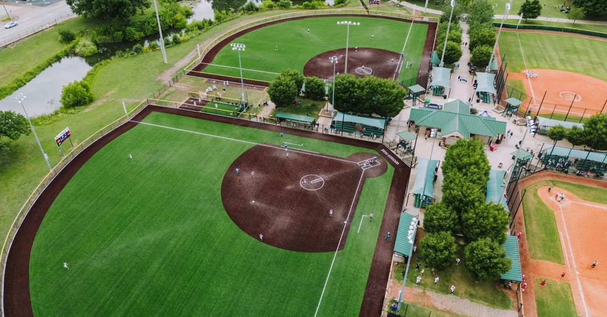 A high-angle aerial shot of baseball fields in Chattanooga, showcasing sports activities and lush greenery.