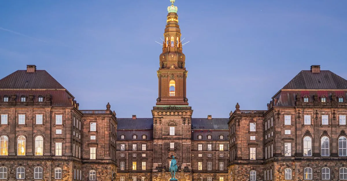 Christiansborg Palace in Copenhagen beautifully illuminated at dusk, showcasing its historic architecture.
