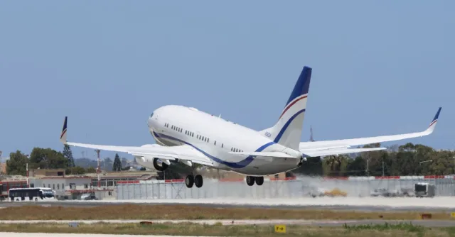 A commercial airplane takes off from a runway on a clear day, showcasing aviation and travel concepts.