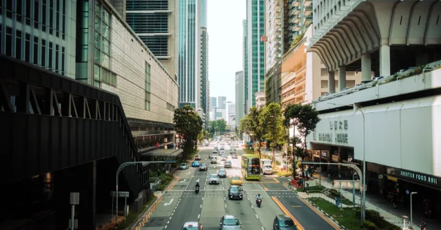 A bustling street in Singapore showcasing modern skyscrapers and urban traffic.