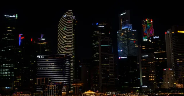 Stunning view of Singapore's skyline at night, featuring illuminated skyscrapers reflecting on the water.