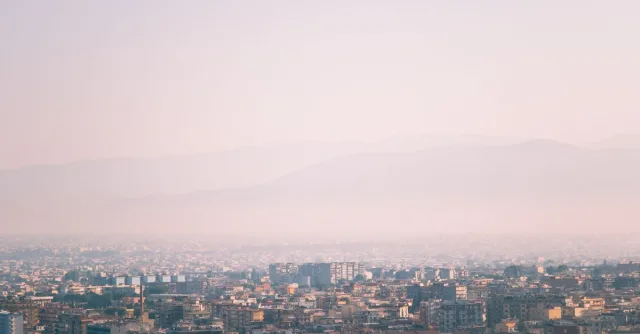 A hazy cityscape view during a misty morning with soft light and urban skyline.
