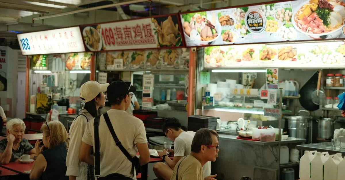 A vibrant scene capturing diners at a Singaporean hawker center enjoying local cuisine.