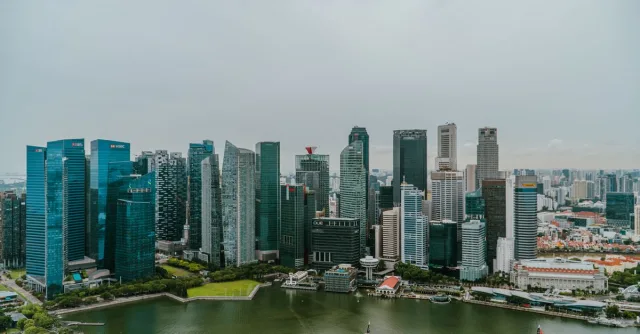 Aerial shot showcasing the modern skyline of Singapore with Marina Bay in the foreground, capturing urban architecture and water scenery.