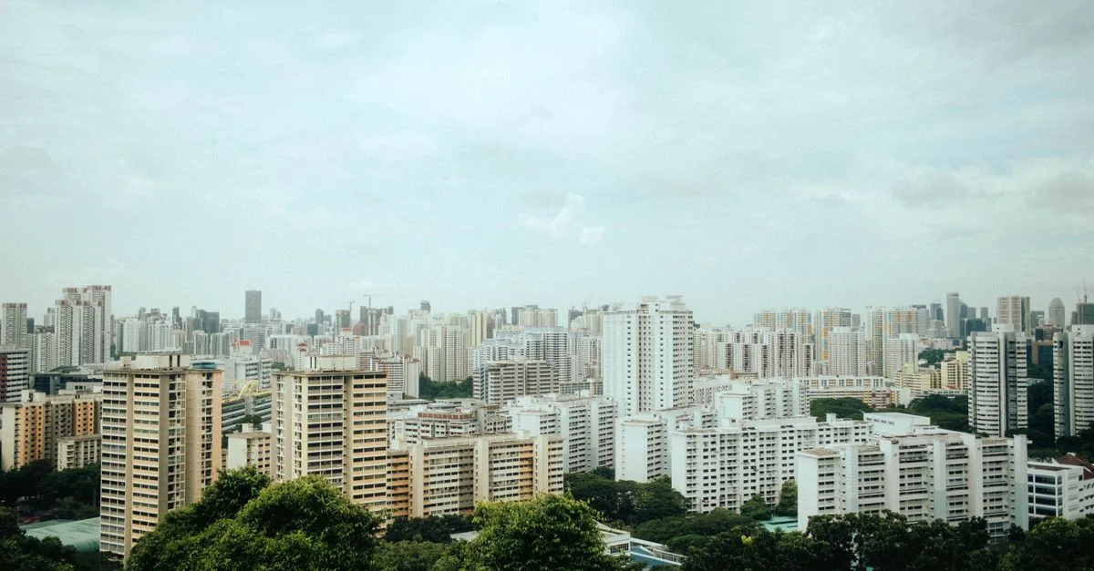 Aerial view of Singapore's urban skyline with modern architecture amidst greenery.