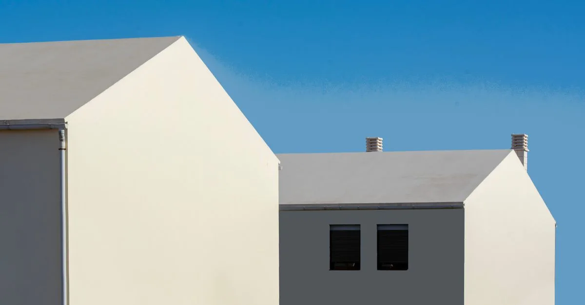 Contemporary minimalist architecture with white houses contrasting a vivid blue sky.