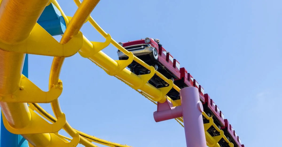 Vivid roller coaster with vibrant tracks under a clear sky, evoking thrill and adventure.