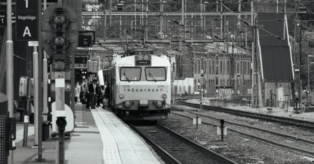 Black and white photo of a train arriving at Jönköping station, Sweden, with passengers boarding.