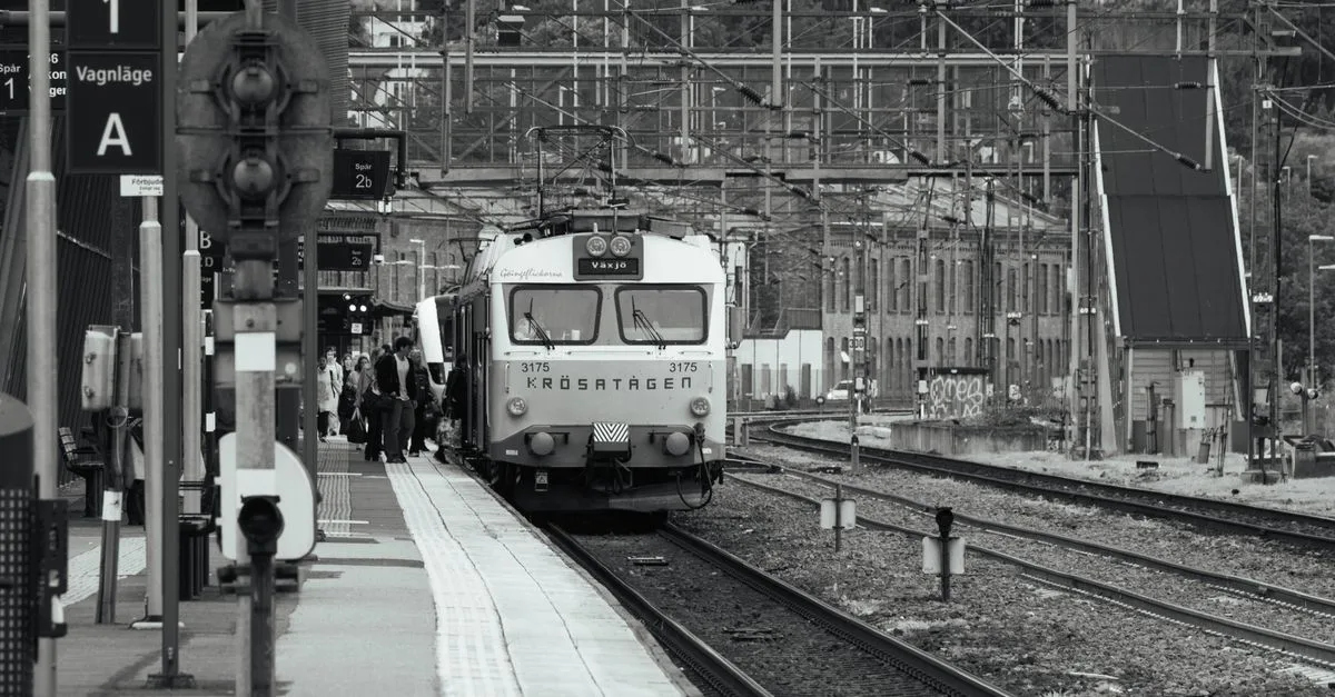 Black and white photo of a train arriving at Jönköping station, Sweden, with passengers boarding.