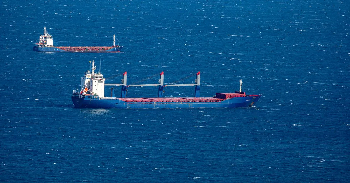 Aerial view of multiple cargo ships navigating through the vast blue ocean, capturing maritime commerce.