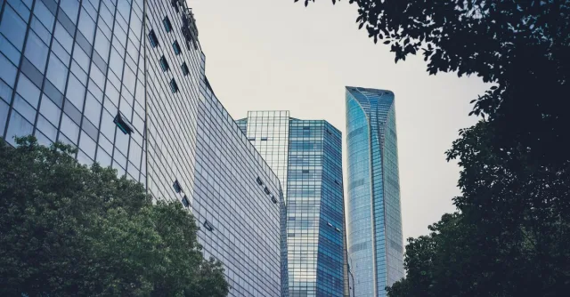 A contemporary cityscape with sleek skyscrapers and green foliage, symbolizing urban harmony.