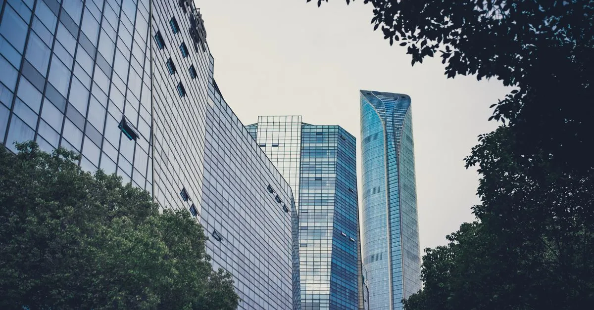 A contemporary cityscape with sleek skyscrapers and green foliage, symbolizing urban harmony.