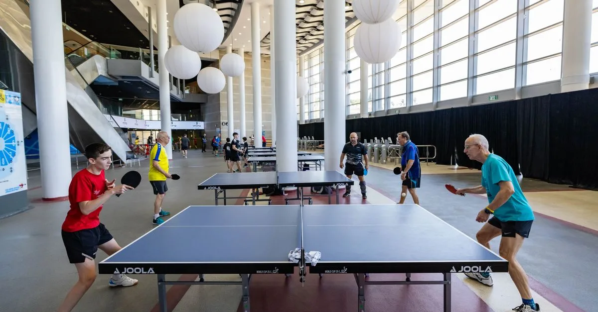 Exciting table tennis game in a modern indoor venue. Players engaged under bright lighting and stylish decor.