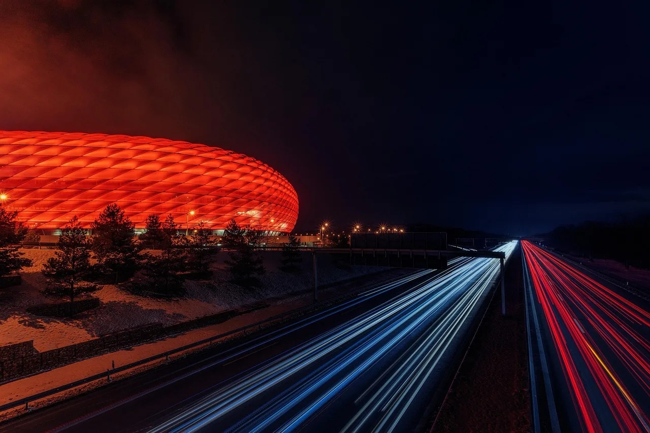 A professional football stadium illuminated under floodlights at night.
