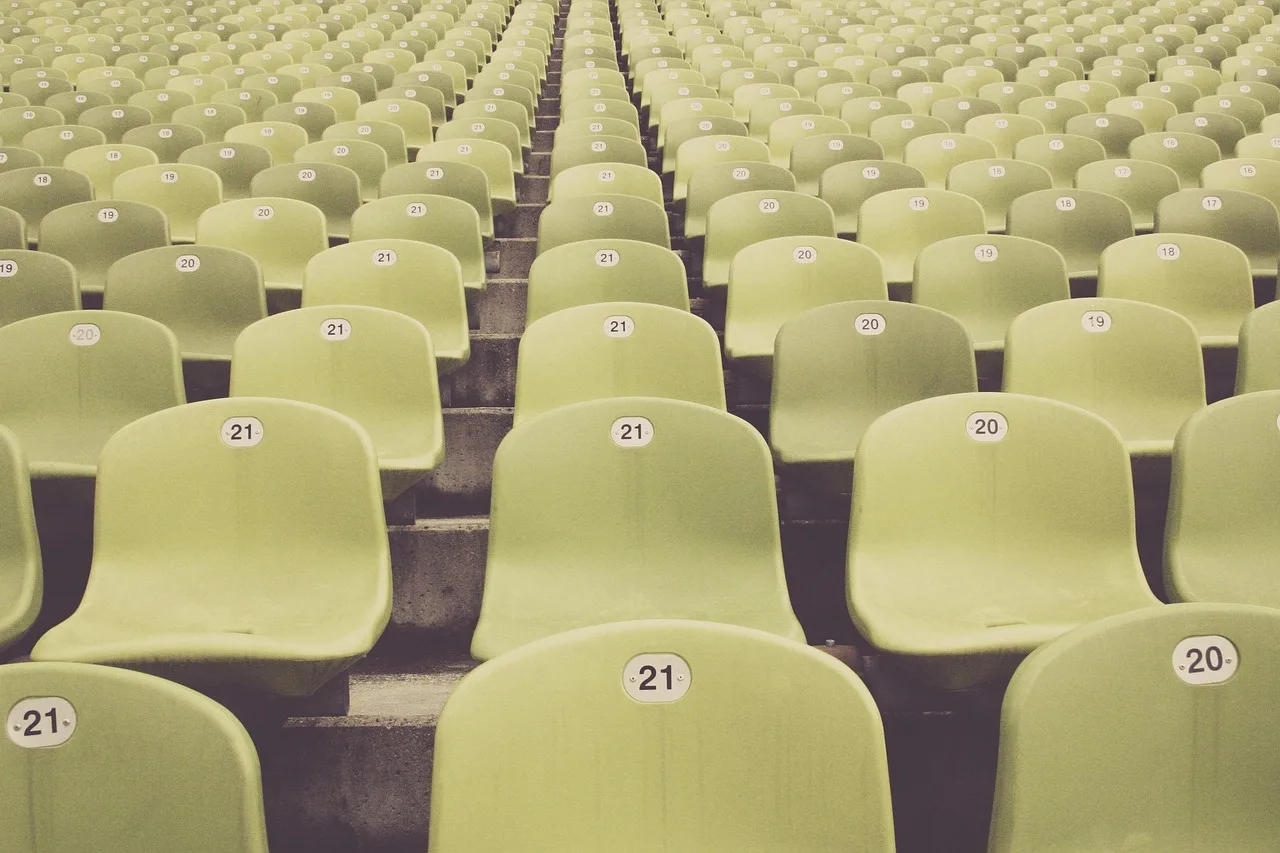 Ein Fußballstadion bei Flutlicht am Abend.