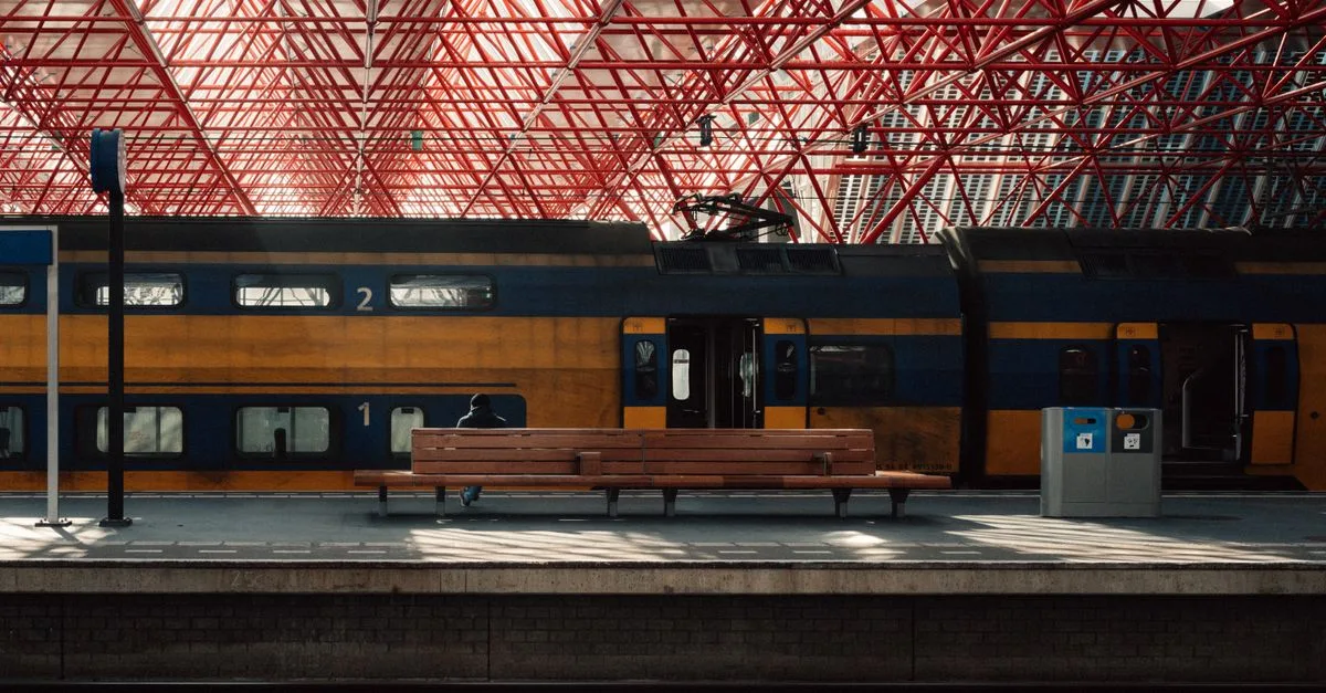 A modern train station platform in Almere with unique red steel architecture and public transport.
