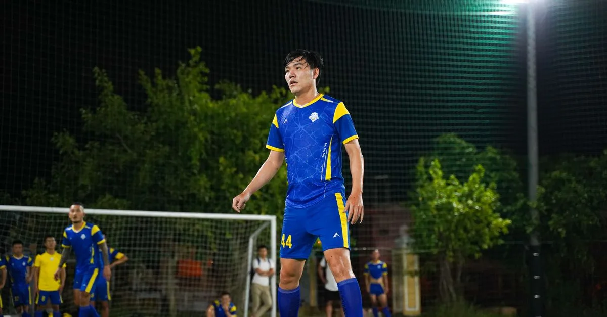 Soccer player in blue and yellow uniform during night game on a lit field.