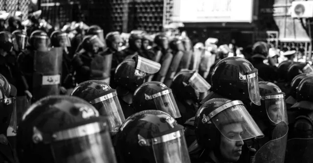 Monochrome photo of Algerian police in riot gear at a protest.