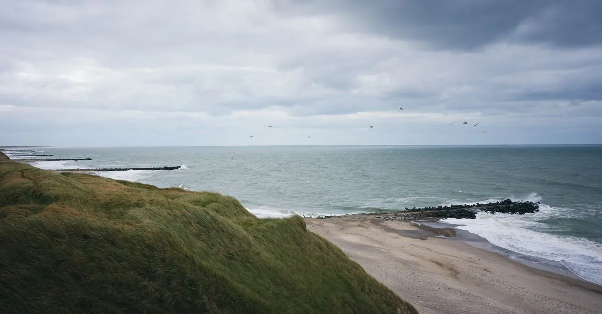 Dramatic coastal scenery in Trans, Denmark with grassy cliffs and stormy skies.