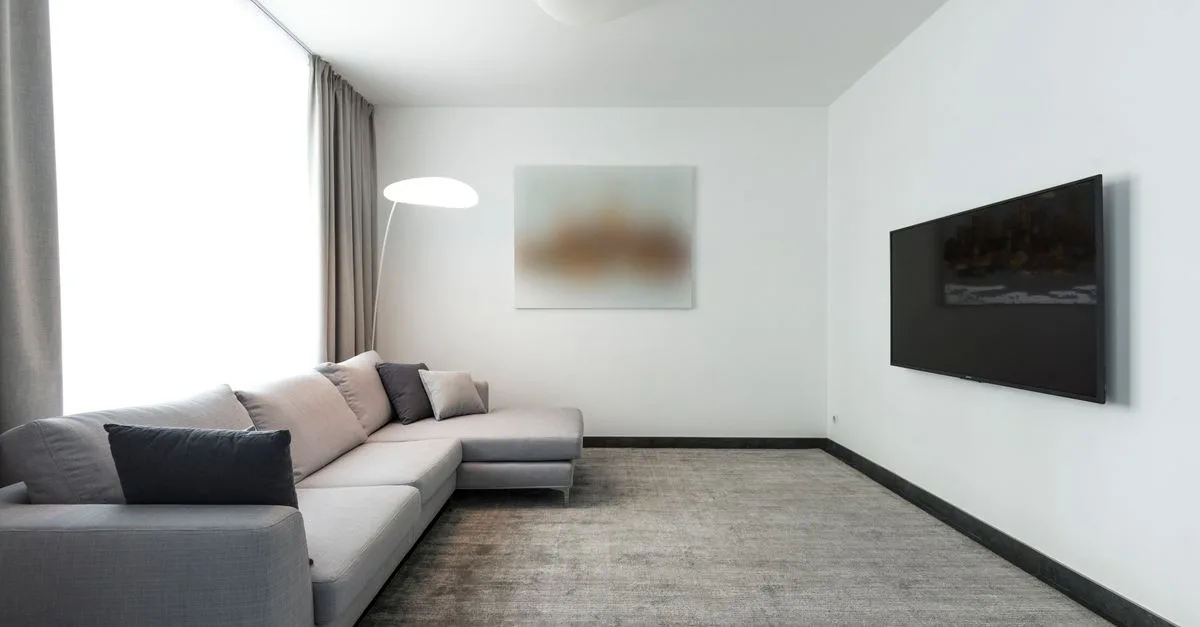 Contemporary living room with a gray sectional sofa and a wall-mounted TV.