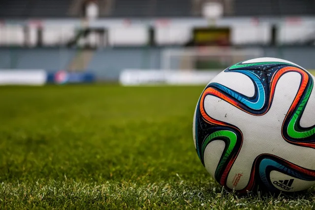 A professional soccer pitch during a match with stadium lights overhead.