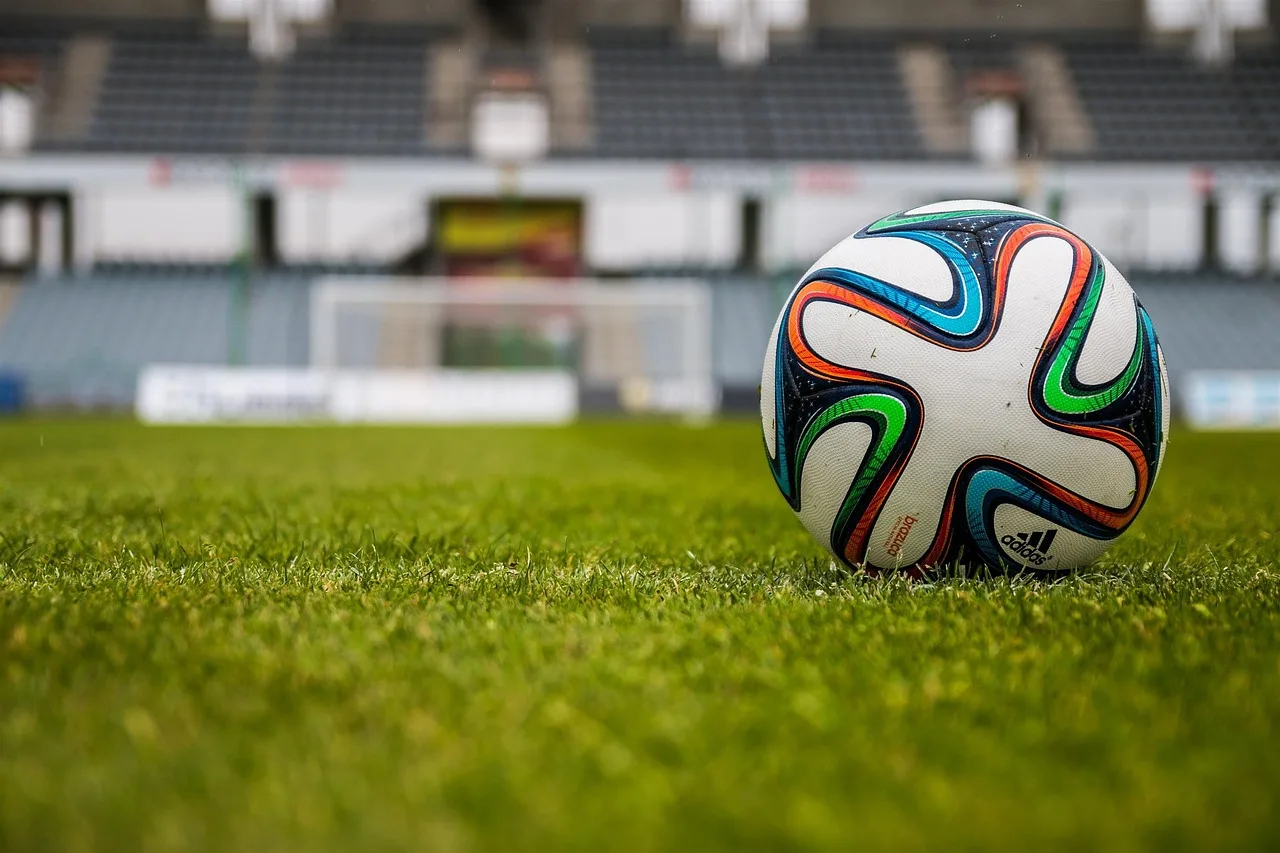 En fotbollsarena upplyst inför en match på kvällen.