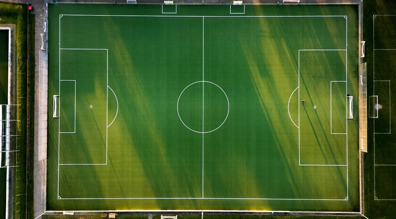 A quiet, professional football pitch at dusk.