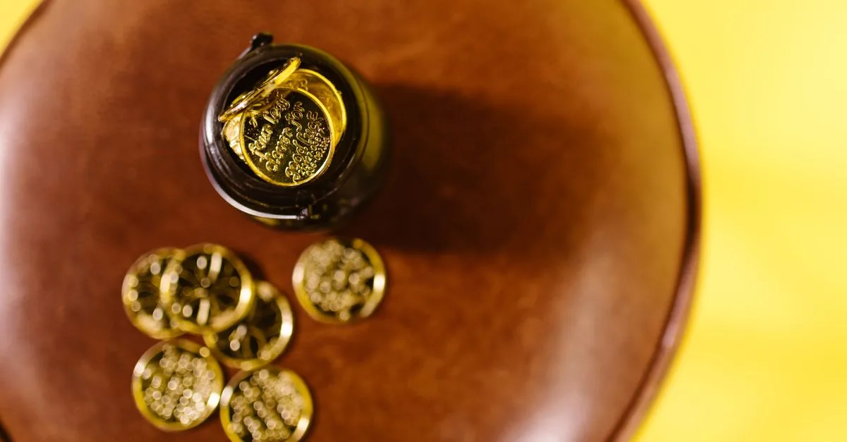Overhead shot of gold coins on a brown surface against a yellow background.