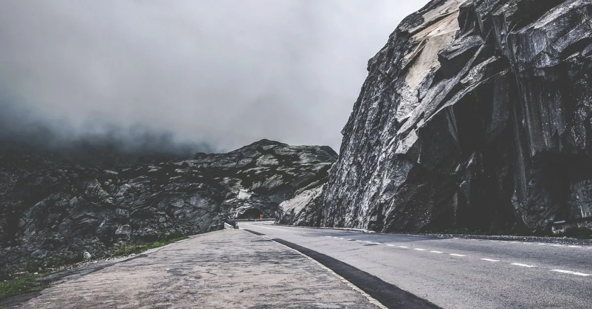 Empty mountain road through foggy Swiss landscapes, perfect for travel and adventure themes.