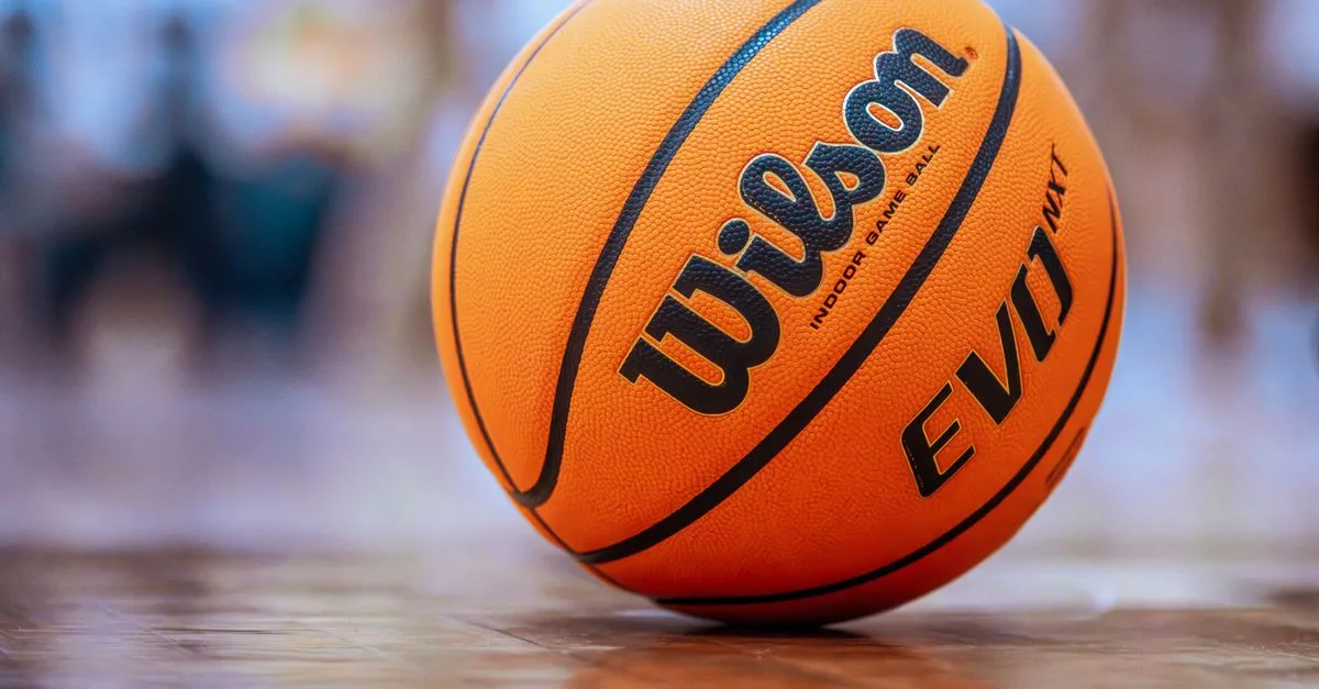 Orange basketball on a polished indoor gym floor, ready for play.