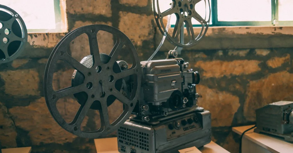Classic vintage film projector displayed in a rustic indoor setting. Perfect for cinema enthusiasts.