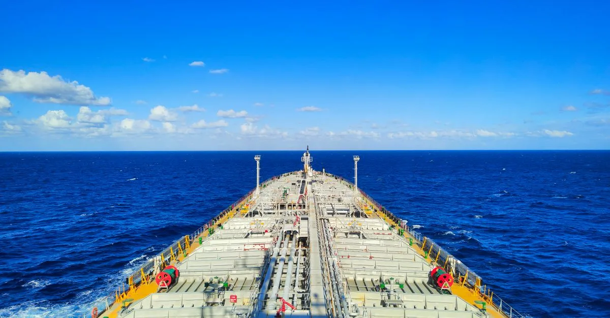 Aerial view of a large shipping tanker amidst a clear blue sky and ocean.