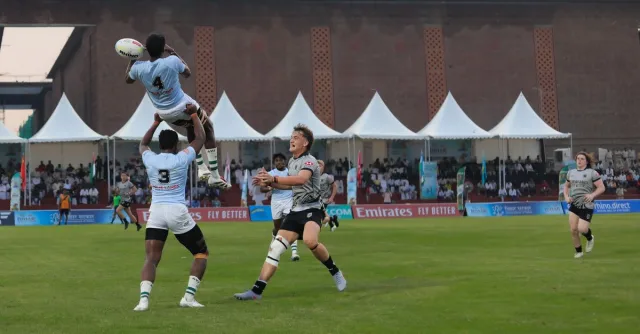 Dynamic rugby match photo showcasing player jumping high for the ball.