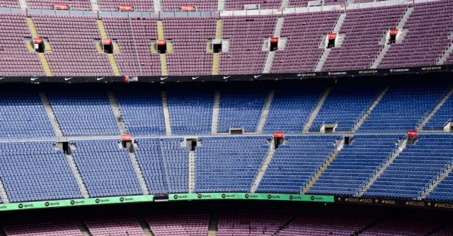 Panoramic view of empty seats in the iconic Barcelona football stadium with vibrant seating arrangement.